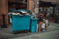 Rows of garbage cans of different colors in an alley in the city center, near a city cafe or restaurant