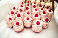 Rows of glasses with raspberry sweet dessert on festive table. Celebration, party, birthday or wedding concept.