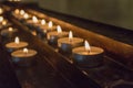 Rows of glowing candles in darkness. Candles with burning falme. Church decoration. Religion and faith background. Royalty Free Stock Photo