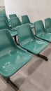 rows of green plastic chairs are used to seat when people waiting in the public area Royalty Free Stock Photo