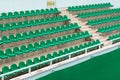 Rows of green spectator seats at sport facility with nobody, diagonal view.