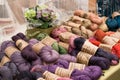 Rows of hand dyed artisan wool yarn for sale on a table market stall