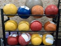 Rows of heavy sports balls stuffed with sand for fitness lie on the shelves as inventory Royalty Free Stock Photo
