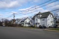 Rows of homes in a town intersection with blue sky roads sidewalks and lines of power and phone Royalty Free Stock Photo