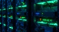 Rows of illuminated computer servers in a dimly lit data center. Each server rack