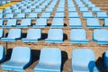 Rows of light blue seats of a small tribune of a stadium
