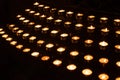 Rows of lighted prayer candles in the darkness in a church Royalty Free Stock Photo