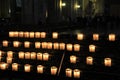 Rows of lit prayer candles in dark church Royalty Free Stock Photo