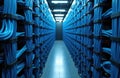 Rows of many blue ethernet cables stretch down hallway in modern data center. Tech infrastructure inside server room with Royalty Free Stock Photo