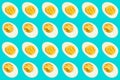 Rows of many halves of boiled eggs on a blue background