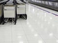 Rows of many luggage trolleys near conveyor belt in the arrival lounge of terminal