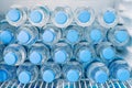 Rows of many transparent plastic bottles with drinking water supply in white refrigerator. Mineral water stack storage in fridge Royalty Free Stock Photo