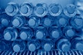 Rows of many transparent plastic bottles with drinking water supply in white refrigerator. Mineral water stack storage in fridge