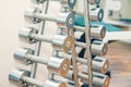 Rows of metal heavy dumbbells on stand in sport gym, physiotherapy clinic. Physical therapy center. Sports equipment for training. Royalty Free Stock Photo