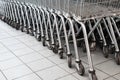 Rows of Metal Shopping Trollies outside shop ready for shoppers to use.