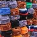 Rows of multi colored russian winter hats with army emblems at the street souvenir shop.