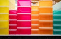 Rows of multi-colored storage bin totes in a retail store shelving space.