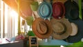 Rows of multi-colored straw hats for sale on shelves in a market Royalty Free Stock Photo