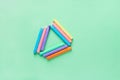 Rows of Multicolored Chalks Crayons Arranged in Triangle on Turquoise Background. Business Creativity Graphic Design Crafts Kids