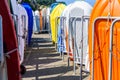 Rows of multicolored dinghies racked vertically in a harbor under a bright sunshine Royalty Free Stock Photo