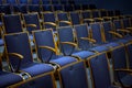 Rows of numbered empty audience seats made of wood and blue upholstery for a theatre, presentation or concert event Royalty Free Stock Photo