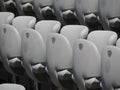 Rows of numbered empty plastic seats at an open-air amphitheater. many audience open theater seats