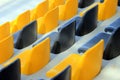 Rows of old dirty plastic black and yellow seats at a stadium Royalty Free Stock Photo