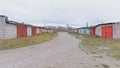 Old worn garageboxes with colorful doors along a dirtroad in Paldiski