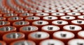 Rows of Orange Cylindrical Batteries with Silver Tops in a Repeating Pattern power energy Royalty Free Stock Photo