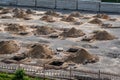 Rows of pits at a construction site. preparation of the site for the installation of piles. a pile of sand