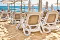 Rows of plastic beach recliners on the beach at a seaside hotel resort