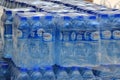 Rows of plastic water bottles stacked in bulk for sale.