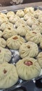 Rows of raw Buryat Buza dish in the kitchen with flour.buuza process making factory traditional asian manti.