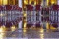 Rows of Red and Aluminum Chairs Lined Up with Reflection in Water