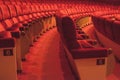 Rows of red cinema seats with number. View of empty theater hall. Comfort chairs in the modern theater interior Royalty Free Stock Photo