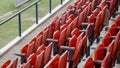 The rows of red folding chairs in the football stadium