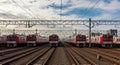 Rows of Red and White Commuter Trains Lined Up on Tracks Under a Cloudy Sky railway transportation Royalty Free Stock Photo