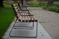 Rows of reddish wood benches on their paneling under the benches is a rectangle of concrete anti-scraping beige paths by the shoes Royalty Free Stock Photo