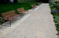 Rows of reddish wood benches on their paneling under the benches is a rectangle of concrete anti-scraping beige paths by the shoes Royalty Free Stock Photo