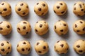 Rows of round chocolate chip cookie dough balls arranged on parchment paper ready for baking in a kitchen setting with even Royalty Free Stock Photo