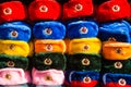 Rows of russian winter hats of different colors with army emblems at the street market at Old Arbat street