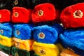 Rows of russian winter hats of different colors with army emblems at the street market at Old Arbat street