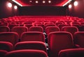rows of seats sit in a dark theatre auditorium with red lighting Royalty Free Stock Photo