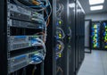 Rows of server racks filled with network equipment are visible in a data center. Various colored Royalty Free Stock Photo