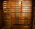 Rows of shelfs containing moveable type and letterpress tools.