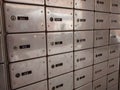 Rows of shiny silver post office boxes, with black number tags