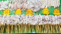 Rows of skewered squid, octopus and fish fillet, neatly displayed at a street food stall