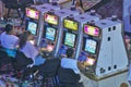 Rows of slot machines and gamblers at Rio Casino in Las Vegas, NV