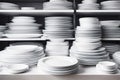 Rows and stacks of white empty plates sit neatly on shelves. Clean dishes