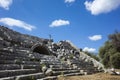 Rows of stone seats of ruins of Theatre in Letoon Ancient City in village Kumluova, Turkey. Sunny day, Tourist stands at top